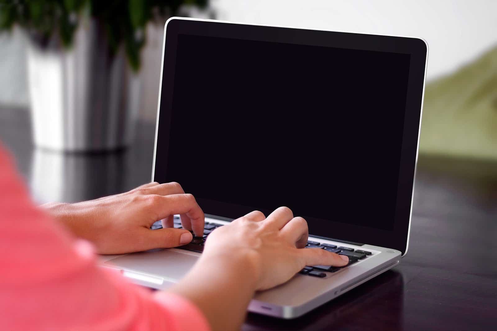 Developer typing on a laptop keyboard, writing a git commit message