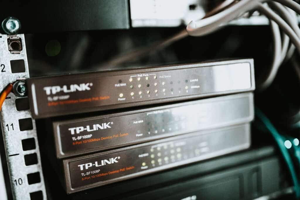 Network switches in a server rack with status LEDs, representing how an AI model router directs requests between models