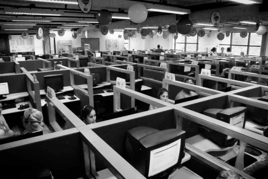 Call center agents at their desks, representing how AI triages support tickets by urgency and category