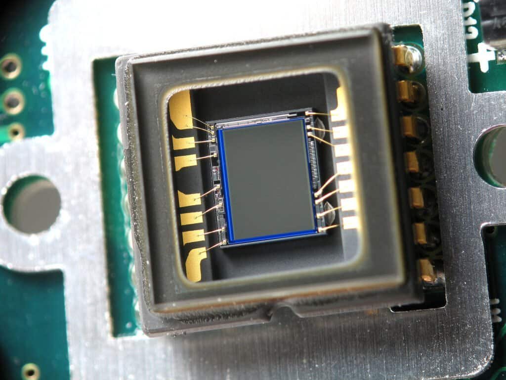 Macro close-up of a webcam CCD image sensor chip, representing the visual input side of multimodal AI