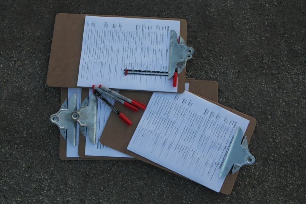 Clipboards holding printed checklists and pens, representing a standard operating procedure document