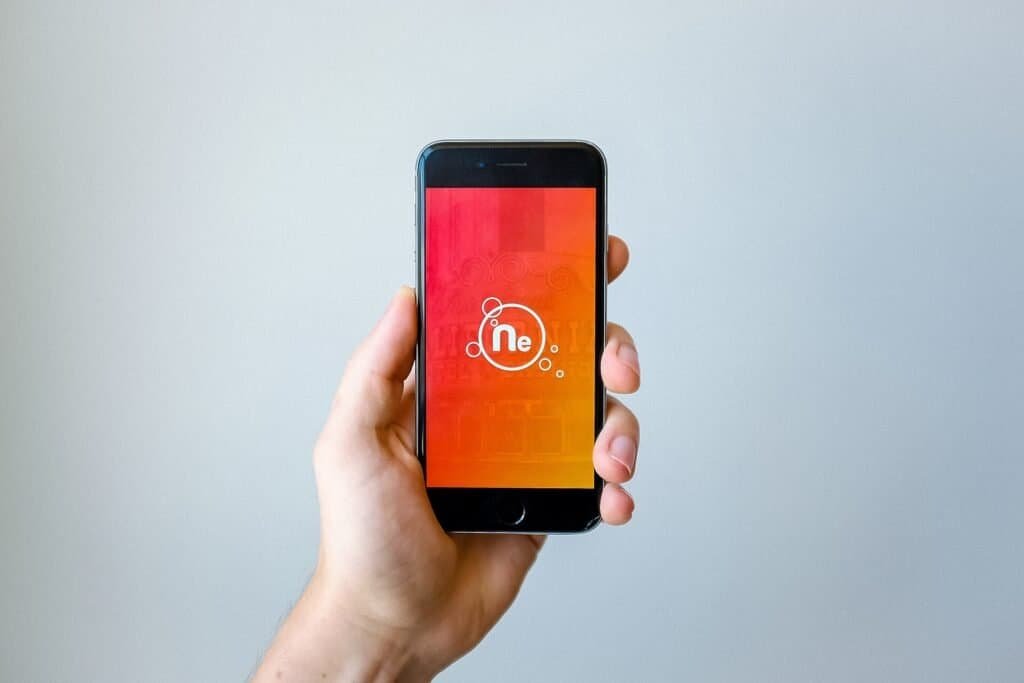 Close-up of a hand holding a smartphone, representing reading and analyzing customer reviews