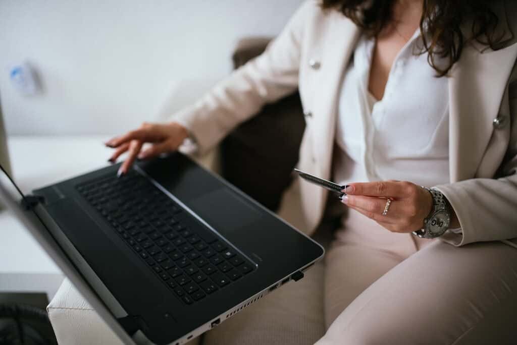 Person completing an online purchase on a laptop, representing upsell and cross-sell email moments