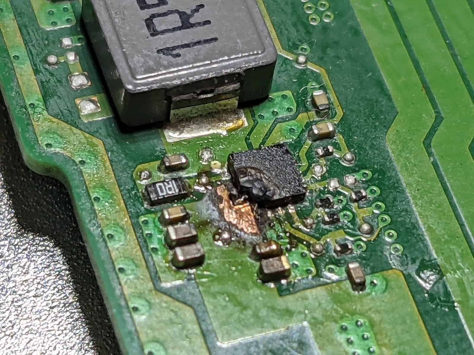 Microscope close-up of a failed component on a circuit board Extreme close-up of a failed electronic component on a circuit board, illustrating a defect caught only under close inspection