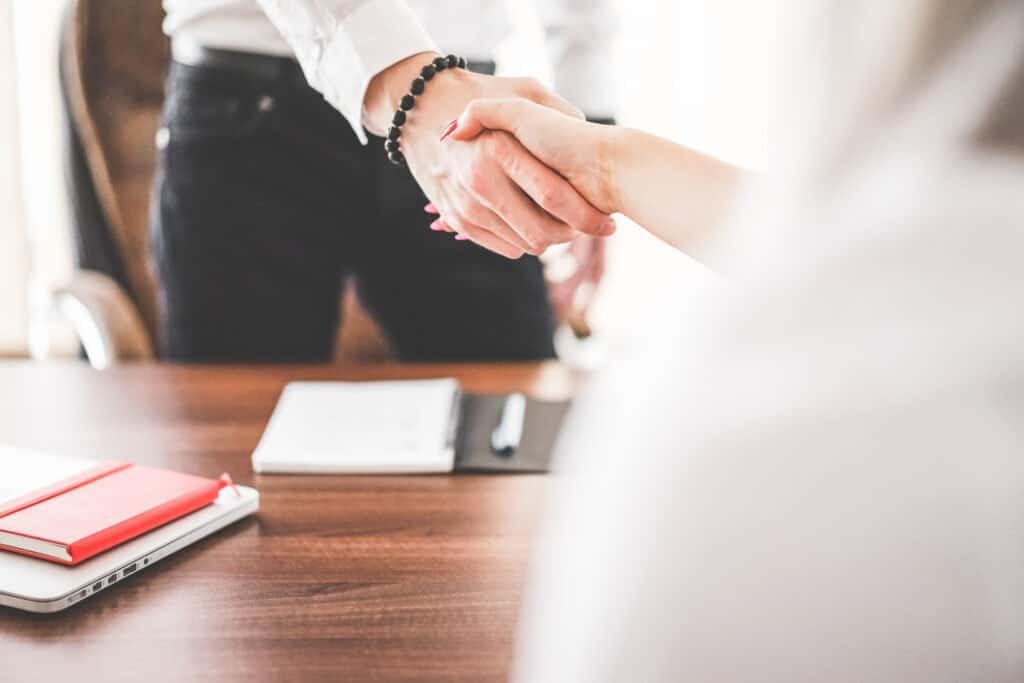A businessman and businesswoman shaking hands in an office setting