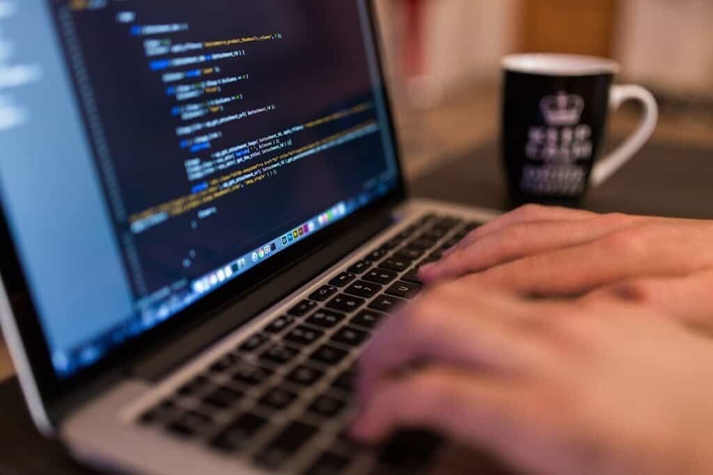 A programmer working at a desktop computer, representing the process of debugging code