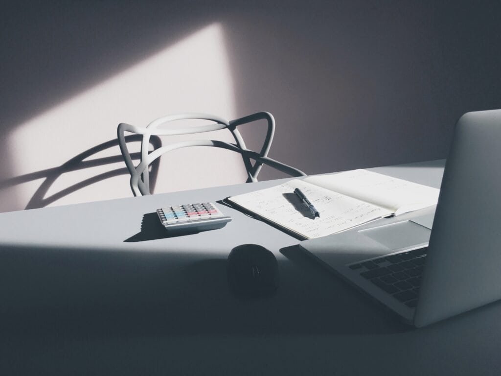 Office desk with a laptop, calculator, and papers, used to illustrate a website content audit