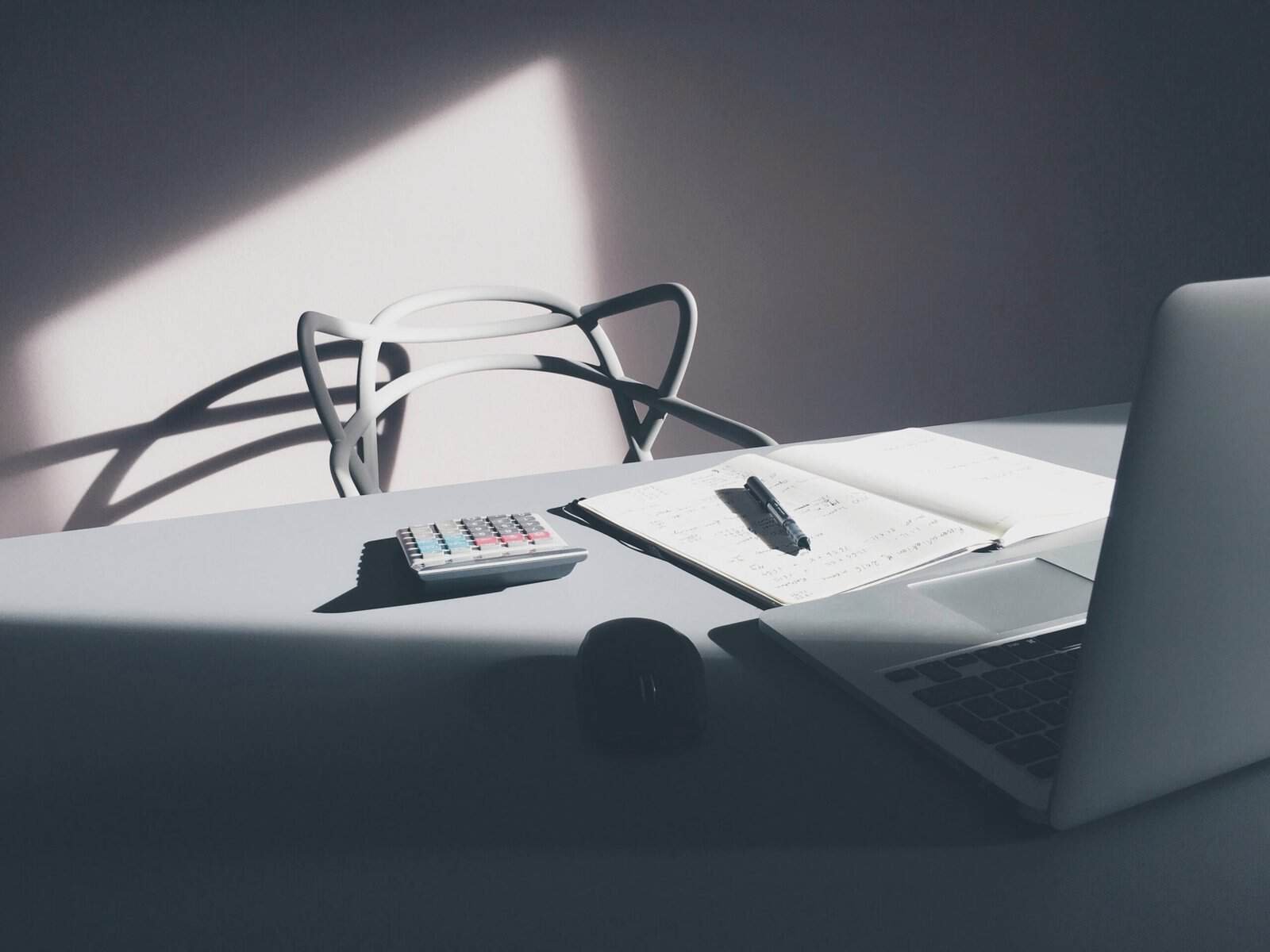 Office desk with a laptop, calculator, and papers, used to illustrate a website content audit