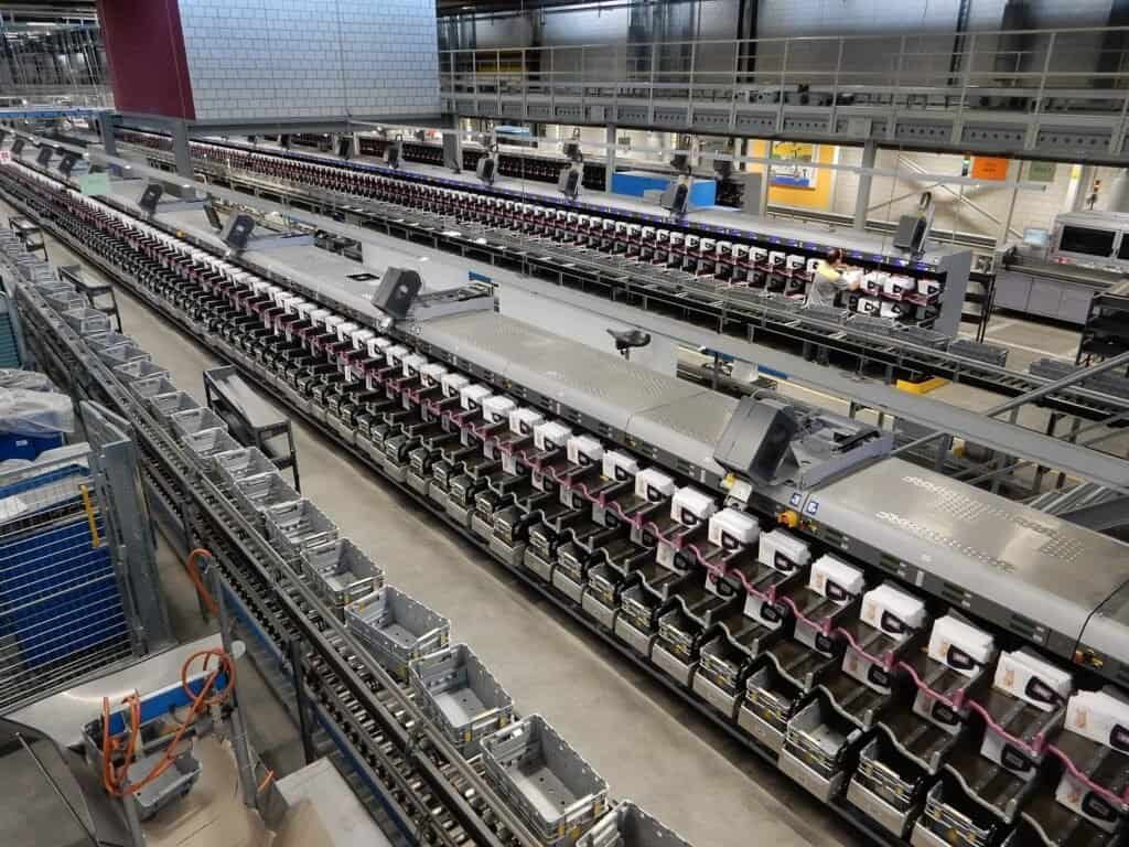 Conveyor belts sorting mail at an automated postal center, representing the stream of changes an inbox sync job has to process in order.