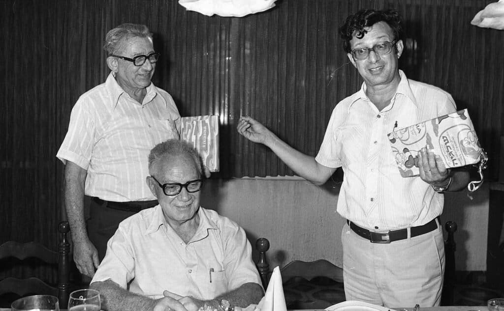A manager speaking and giving direction at a team meeting, representing delegating tasks clearly