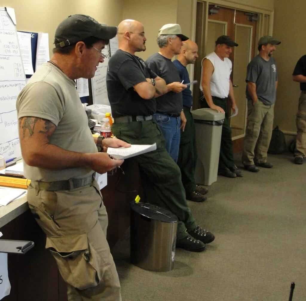 A team gathered in an office for a morning briefing, representing a daily standup update