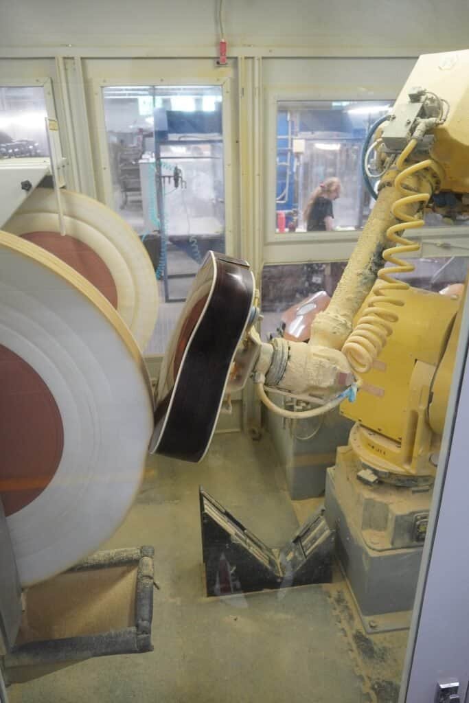 An industrial robotic arm performing a precise, goal-directed task on a factory floor, representing an autonomous AI agent