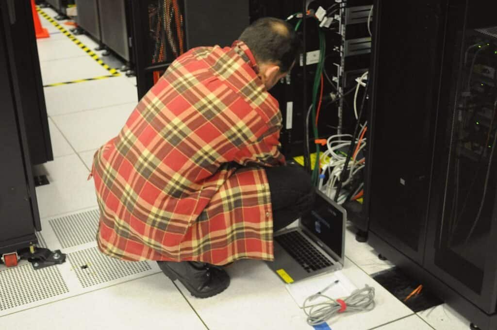 Technician working on a server rack in a data center, representing API infrastructure and quota limits