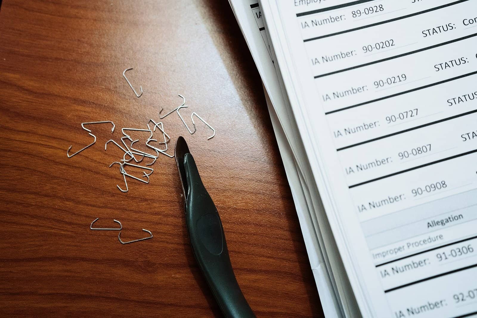 Stack of paper documents, representing the source material a grounding prompt restricts an AI model to Stack of paper documents and office supplies, representing source documents used to ground an AI prompt