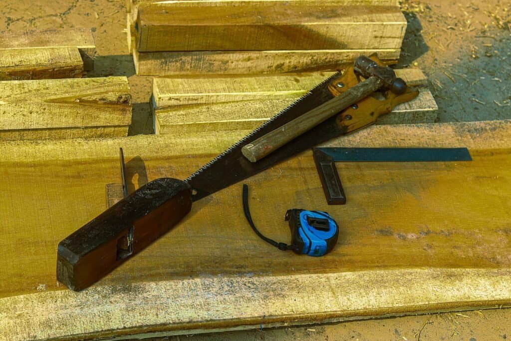 Woodworking hand tools arranged on timber planks, representing a clear step-by-step process